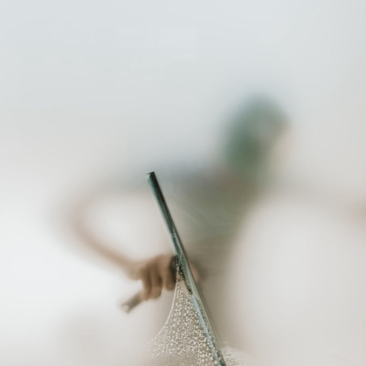 A window cleaner behind a foggy pane of glass